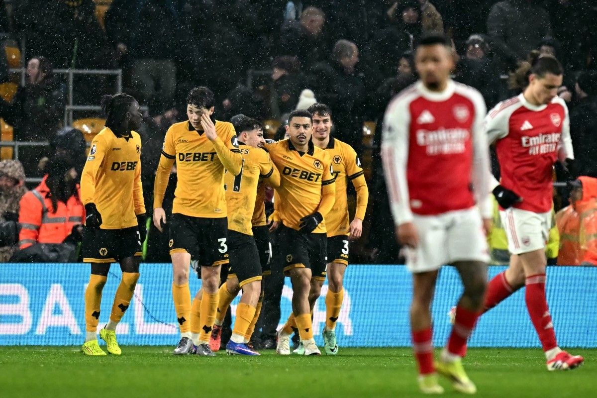 Para pemain Wolverhampton Wanderers merayakan gol ke gawang Arsenal di tengah hujan saat pertandingan Liga Inggris.