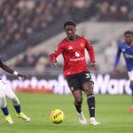 Gelandang muda MU, Kobbie Mainoo, sedang menggiring bola melewati pemain Everton dalam pertandingan Premier League di Goodison Park.