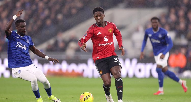 Gelandang muda MU, Kobbie Mainoo, sedang menggiring bola melewati pemain Everton dalam pertandingan Premier League di Goodison Park.