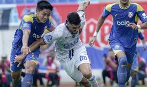 Pemain Arema FC sedang berduel memperebutkan bola dengan pemain Persijap Jepara dalam laga Super League.