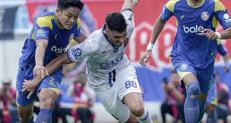 Pemain Arema FC sedang berduel memperebutkan bola dengan pemain Persijap Jepara dalam laga Super League.