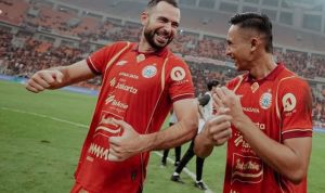 Selebrasi ceria dua pemain Persija Jakarta di tengah lapangan setelah mencetak gol, menunjukkan kekompakan tim menjelang laga tandang.
