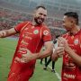 Selebrasi ceria dua pemain Persija Jakarta di tengah lapangan setelah mencetak gol, menunjukkan kekompakan tim menjelang laga tandang.