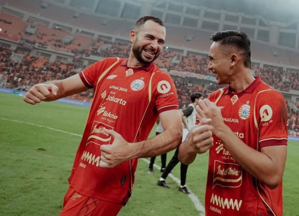 Selebrasi ceria dua pemain Persija Jakarta di tengah lapangan setelah mencetak gol, menunjukkan kekompakan tim menjelang laga tandang.