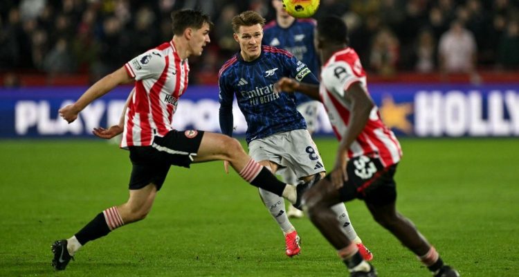 brentford-vs-arsenal-hasil-imbang-liga-inggris-2.jpg Martin Odegaard dari Arsenal dikepung pemain Brentford dalam pertandingan Liga Inggris yang berakhir imbang, memanaskan persaingan gelar dengan Man City.