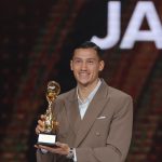 Jay Idzes tersenyum memegang trofi penghargaan di panggung PSSI Awards 2026 dengan latar belakang tulisan JAY.
