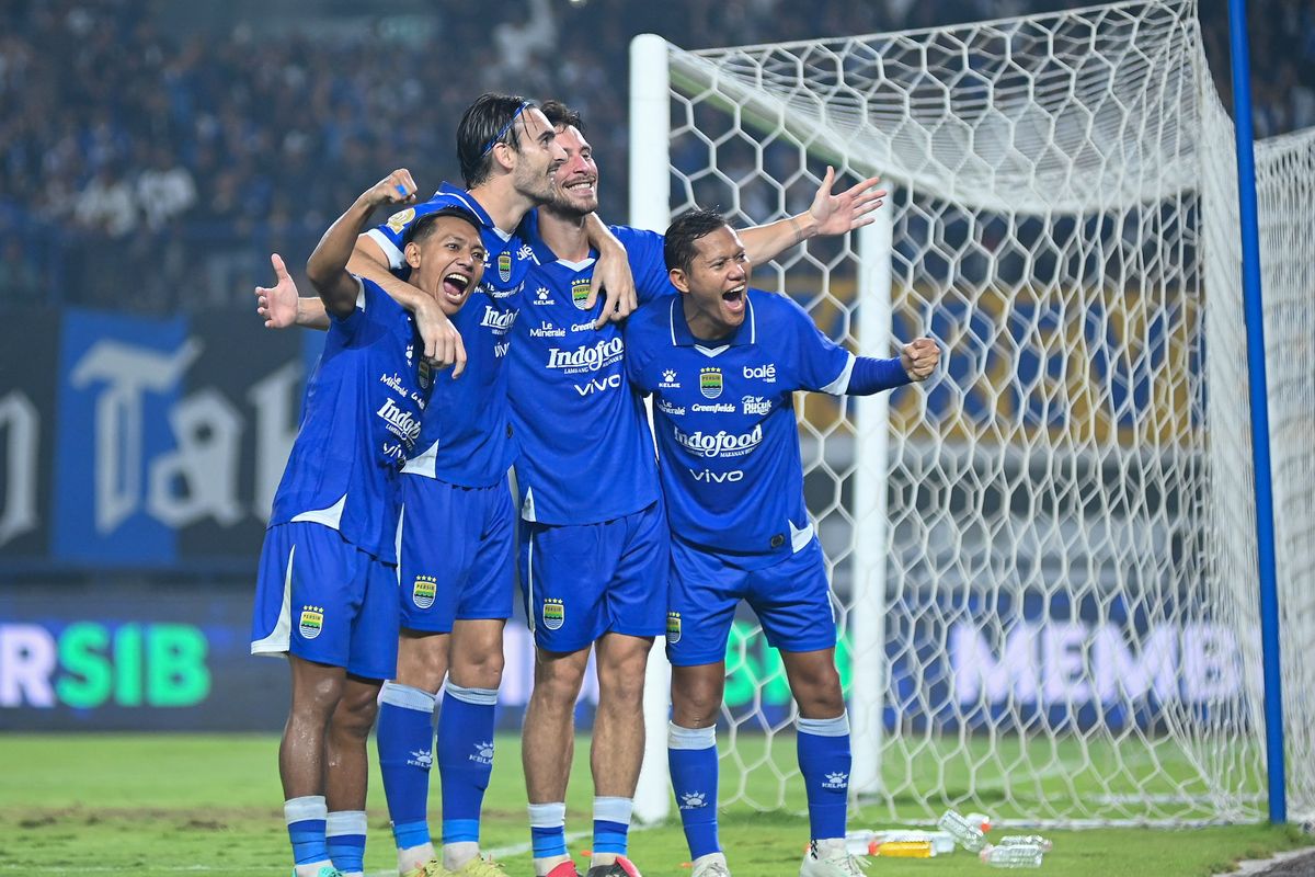 Empat pemain Persib Bandung mengenakan jersey biru merayakan gol dengan penuh suka cita di depan gawang dalam pertandingan kandang melawan Persik Kediri.
