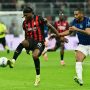 Pemain AC Milan bernomor punggung 10 sedang mengontrol bola saat melawan bek Inter Milan dalam pertandingan Derby della Madonnina di San Siro.