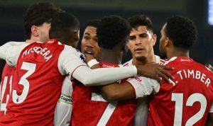 Para pemain Arsenal, termasuk Jurrien Timber dan Bukayo Saka, saling berangkulan merayakan kemenangan setelah duel sengit melawan Brighton.