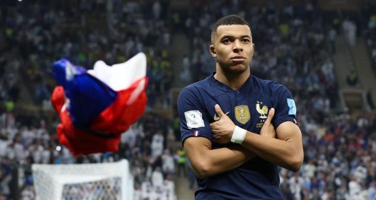 kylian-mbappe-pulih-jelang-prancis-vs-brasil.webp Penyerang Prancis Kylian Mbappe melipat tangan di depan dada dengan ekspresi fokus di Final Piala Dunia 2022.