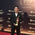 Rizky Ridho berpose memegang trofi penghargaan di karpet merah PSSI Awards 2026 dengan latar belakang sponsor.