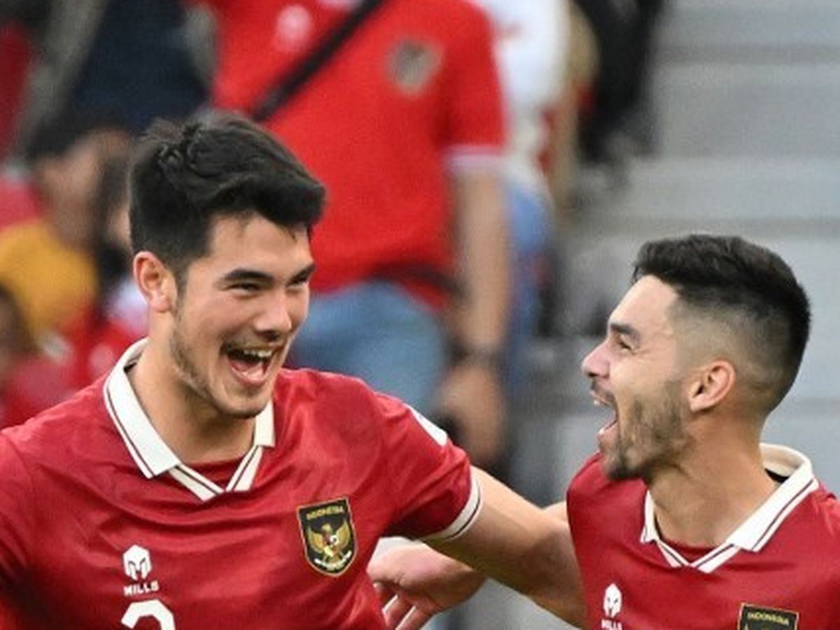 Elkan Baggott dan Jordi Amat, dua pemain Timnas Indonesia dengan jersey merah, tertawa gembira saat merayakan kemenangan di lapangan.