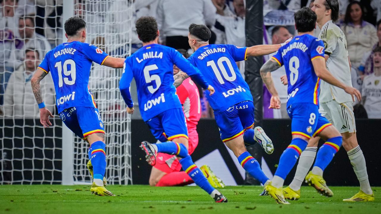 Para pemain Getafe CF, dengan nomor punggung 19, 5, dan 10 terlihat jelas, sedang melakukan perayaan gol di kandang Real Madrid.