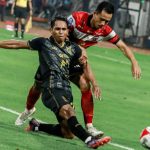 Perebutan bola sengit antara pemain Madura United dan Malut United di tengah lapangan.