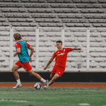 eliano-reijnders-bule-baru-latihan-timnas-indonesia.jpg Eliano Reijnders melakukan duel bola dalam sesi latihan Timnas Indonesia di stadion dengan latar belakang tribun kosong.