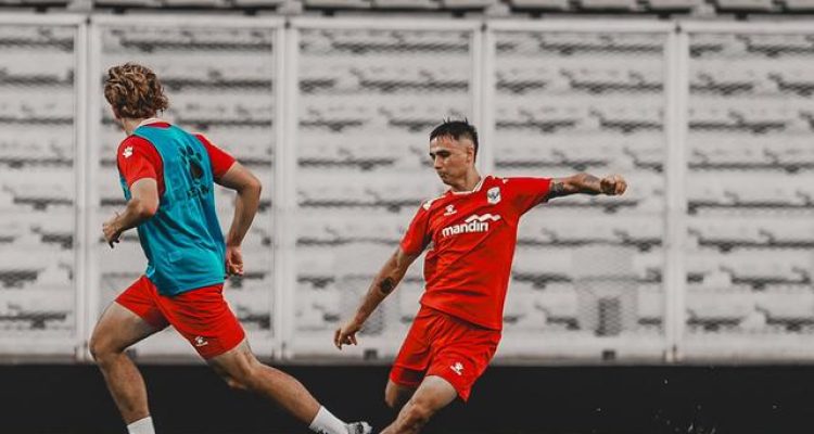 eliano-reijnders-bule-baru-latihan-timnas-indonesia.jpg Eliano Reijnders melakukan duel bola dalam sesi latihan Timnas Indonesia di stadion dengan latar belakang tribun kosong.