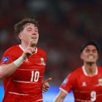 Dua pemain Timnas Indonesia berselebrasi setelah mencetak gol melawan Saint Kitts and Nevis, dengan seorang pemain mengangkat satu jari ke atas.