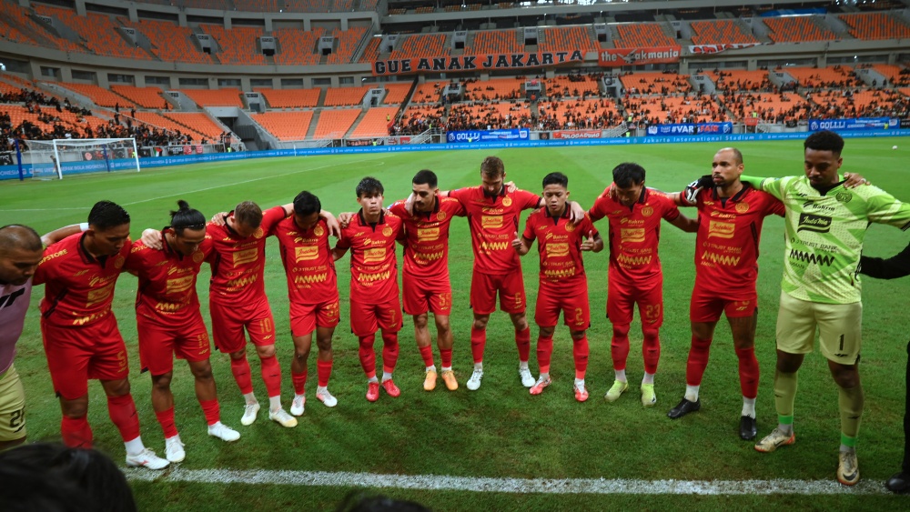 Para pemain tim sepak bola dalam formasi lingkaran sebelum pertandingan BRI Super League di Jakarta International Stadium.