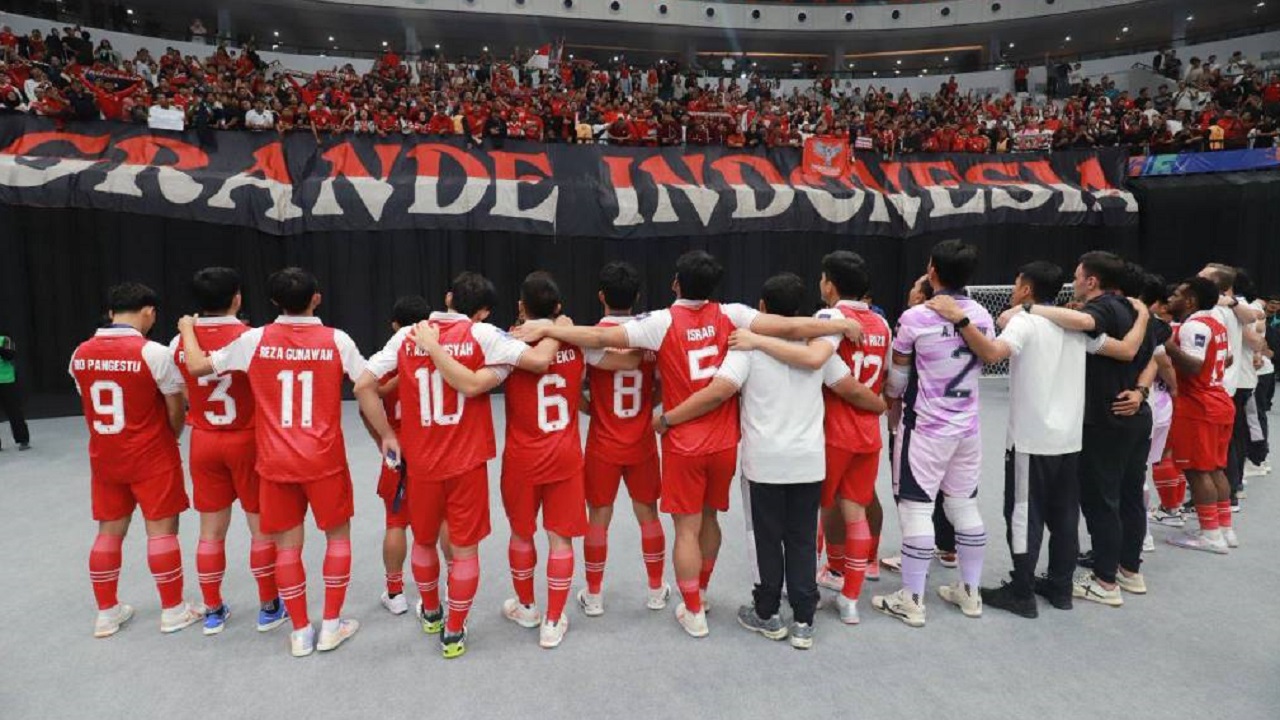 Para pemain Timnas Futsal Indonesia berdiri merangkul satu sama lain menghadap suporter sebagai simbol kesiapan skuad pilihan pelatih untuk Piala AFF Futsal 2026.