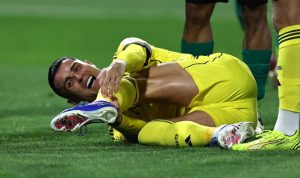 Cristiano Ronaldo terkapar di lapangan sambil memegangi kakinya karena mengalami cedera hamstring saat bertanding.