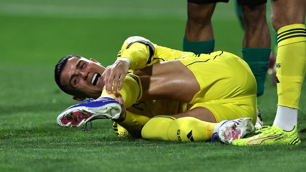 Cristiano Ronaldo terkapar di lapangan sambil memegangi kakinya karena mengalami cedera hamstring saat bertanding.
