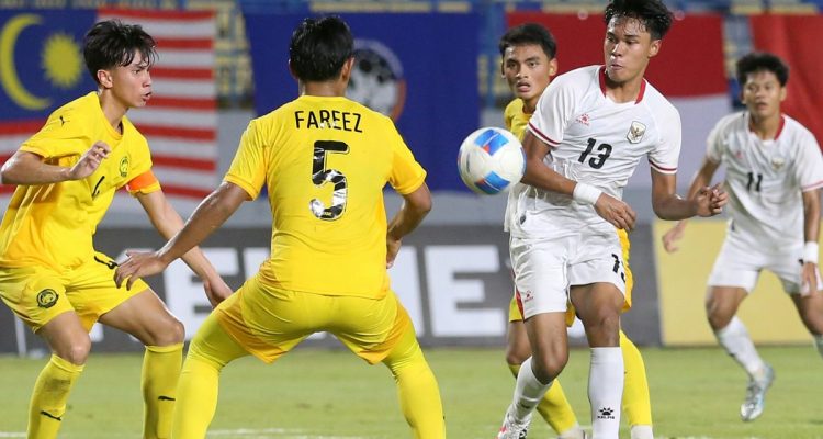 Pemain Timnas U17 Indonesia nomor punggung 13 sedang mengontrol bola di tengah kepungan pemain Malaysia di ajang Piala AFF 2026.