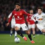 Pemain Manchester United bernomor punggung 10 sedang menggiring bola dibayangi pemain Leeds United dalam pertandingan di Old Trafford.