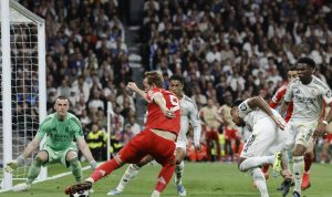 Harry Kane melakukan tendangan ke gawang Real Madrid yang dijaga Andriy Lunin dalam pertandingan Liga Champions.