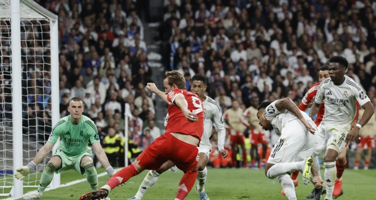 Harry Kane melakukan tendangan ke gawang Real Madrid yang dijaga Andriy Lunin dalam pertandingan Liga Champions.