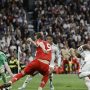 Harry Kane melakukan tendangan ke gawang Real Madrid yang dijaga Andriy Lunin dalam pertandingan Liga Champions.