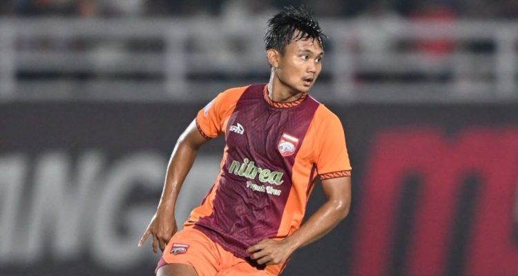Pemain Borneo FC sedang bertanding di lapangan mengenakan jersey oranye dan merah marun.