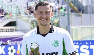 Jay Idzes tersenyum bangga memegang trofi Man of the Match saat mengenakan jersey U.S. Sassuolo setelah pertandingan melawan Fiorentina.