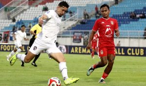 Duel sengit perebutan bola antara pemain Arema FC berbaju putih dan pemain Malut United berbaju merah dalam pertandingan Liga 1.