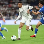 Pemain Real Madrid sedang menggiring bola di bawah tekanan pemain Deportivo Alaves dalam laga sengit Real Madrid vs Alaves.