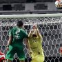 Kiper Madura United menghalau bola di udara saat ditekan pemain Persebaya Surabaya dalam laga Derbi Suramadu di Stadion Gelora Bung Tomo.