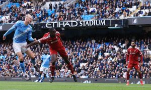 Erling Haaland dari Manchester City berduel udara dengan pemain bertahan Liverpool di Etihad Stadium.