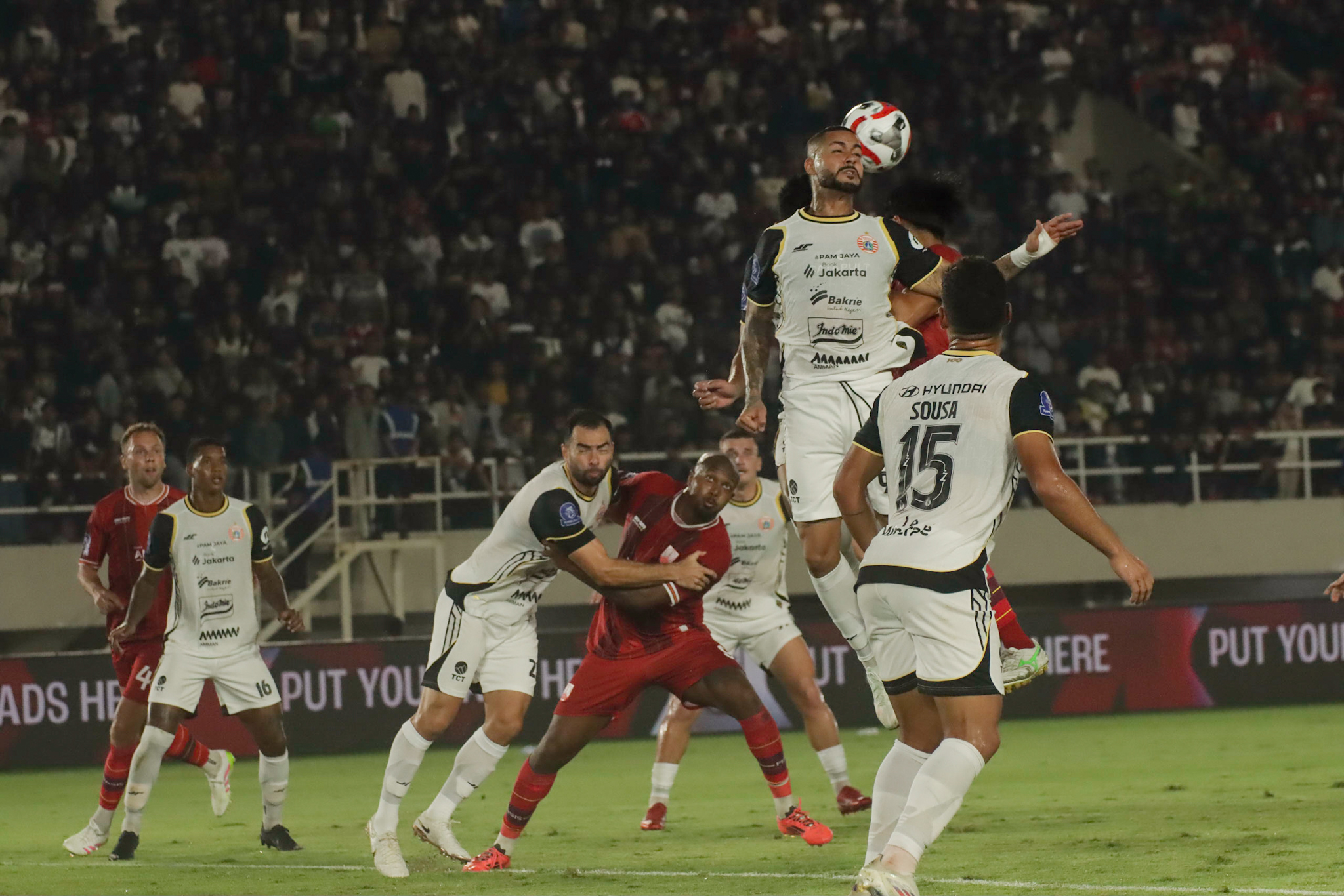 Aksi duel udara sengit antara pemain Persija Jakarta dan pemain lawan dalam pertandingan BRI Super League.