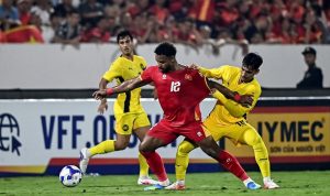 Pemain Timnas Vietnam nomor punggung 12 sedang berduel sengit memperebutkan bola dengan pemain Malaysia di Kualifikasi Piala Asia.