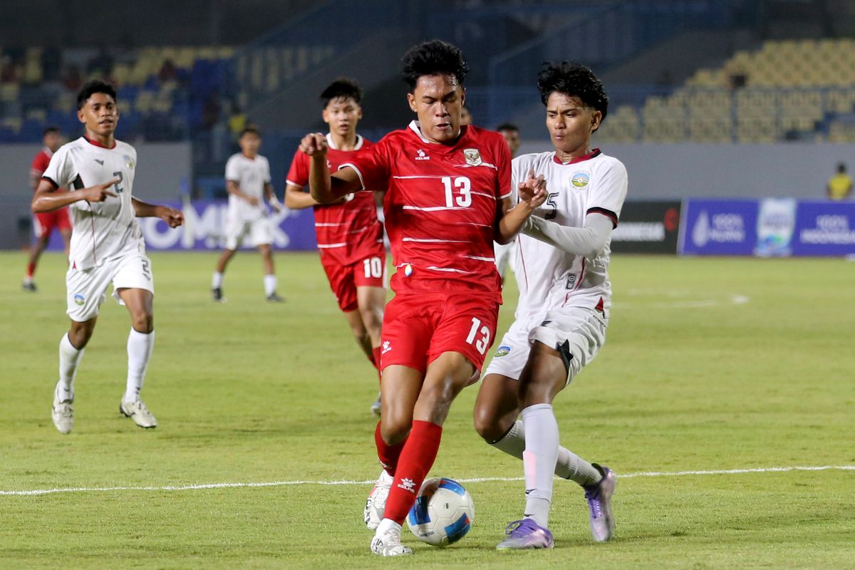 Pemain Timnas Indonesia U-17 nomor punggung 13 sedang berduel memperebutkan bola dengan pemain Timor Leste dalam laga Piala AFF U-17 2026.