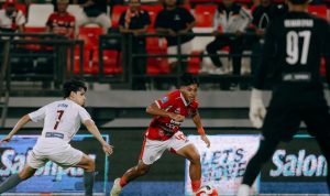 Pemain Bali United beraksi menggiring bola saat menghadapi tekanan pertahanan PSM Makassar dalam sebuah pertandingan sepak bola.