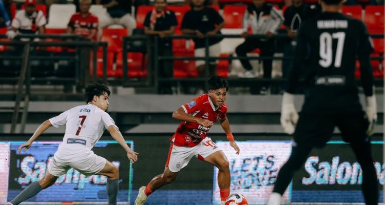 Pemain Bali United beraksi menggiring bola saat menghadapi tekanan pertahanan PSM Makassar dalam sebuah pertandingan sepak bola.