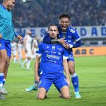 Pemain Persib Bandung berselebrasi di lapangan dengan jersey biru berlogo Indofood.