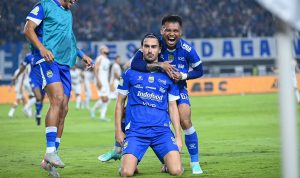 Pemain Persib Bandung berselebrasi di lapangan dengan jersey biru berlogo Indofood.