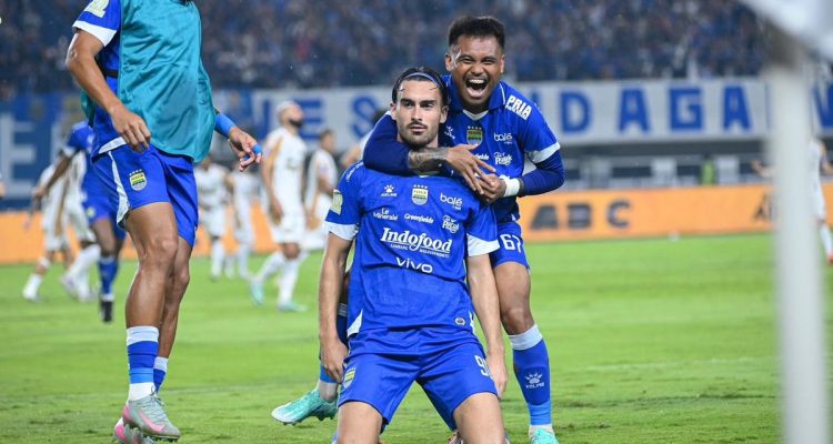 Pemain Persib Bandung berselebrasi di lapangan dengan jersey biru berlogo Indofood.