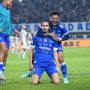 Pemain Persib Bandung berselebrasi di lapangan dengan jersey biru berlogo Indofood.