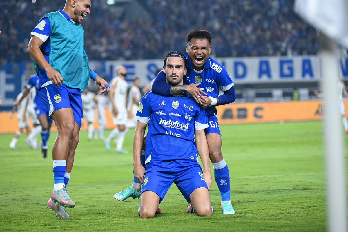 Pemain Persib Bandung berselebrasi di lapangan dengan jersey biru berlogo Indofood.