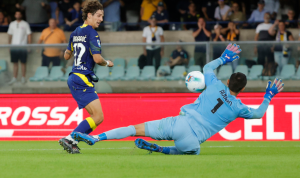 Emil Audero melakukan penyelamatan akrobatik dengan menepis bola saat berhadapan satu lawan satu dengan pemain lawan, memperlihatkan komitmennya untuk menghindarkan tim dari degradasi.