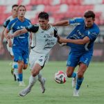 Duel sengit antara pemain Persija Jakarta dengan pemain lawan dalam perebutan bola di lapangan.