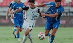 Duel sengit antara pemain Persija Jakarta dengan pemain lawan dalam perebutan bola di lapangan.