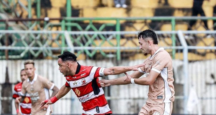 Duel sengit perebutan bola antara pemain Madura United dan Dewa United di lapangan dalam laga Madura United vs Dewa United.